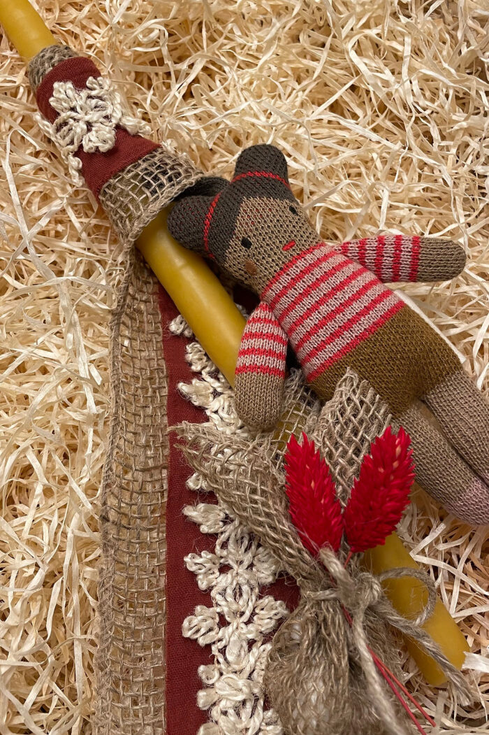 A beeswax candle decorated with a dark skinned girl with buns